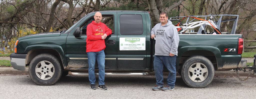 Phil and Patrick standing in front of their green pick up truck