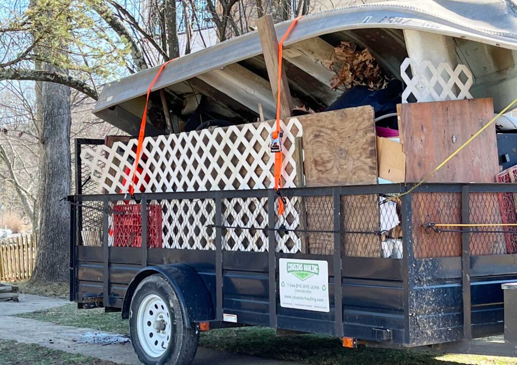 Trailer filled with old wood, fencing, and boat